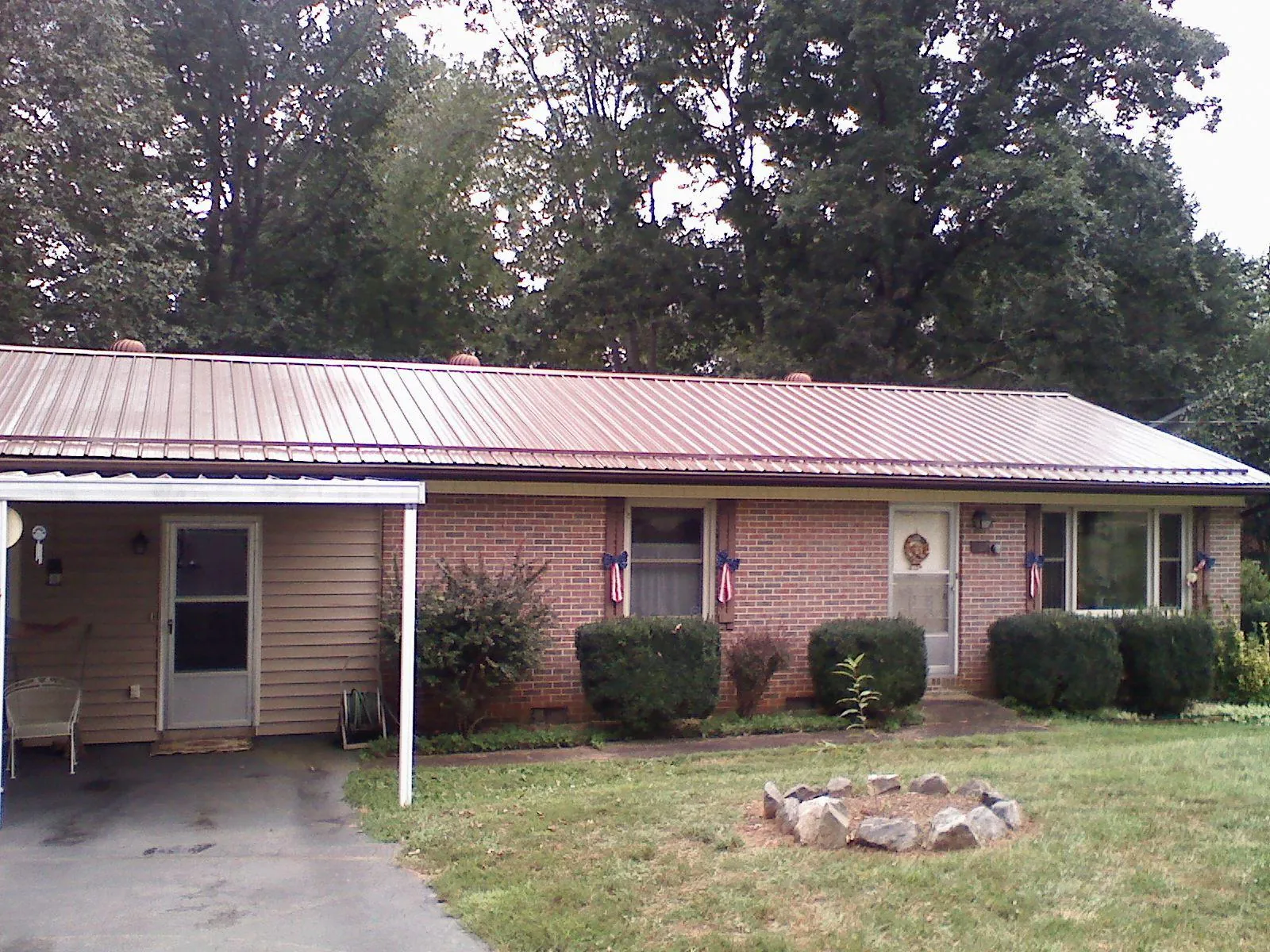 Bronze metal roof and carport on a brick ranch home — Roof Repair work by our crew in Clark Mills