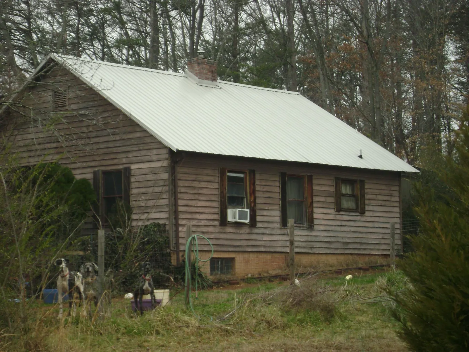 White metal roof on an old wood sided farmhouse, from a Metal Roof Installation job in Clark Mills